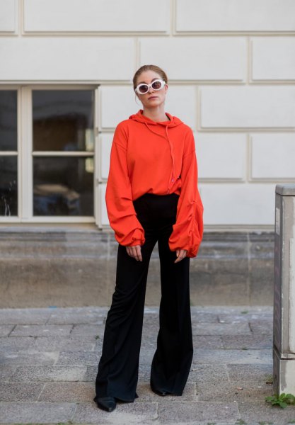 Orange hoodie with black bell bottoms and boots