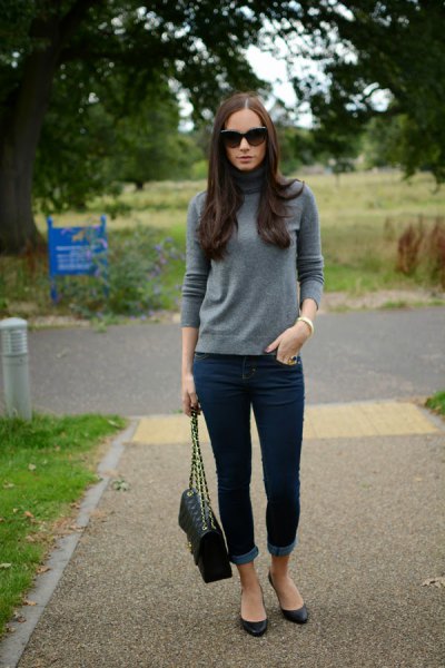 Gray cashmere sweater with stand-up collar and dark blue skinny jeans with cuffs