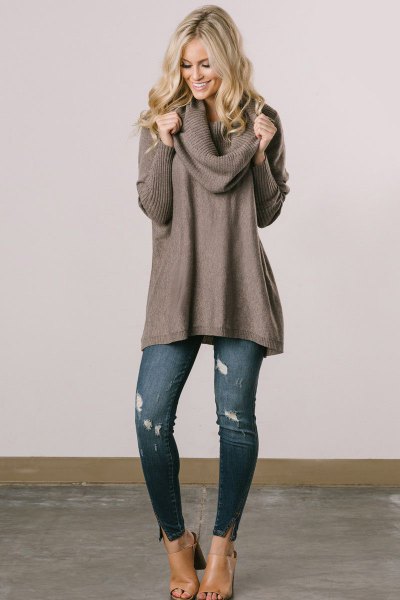 Wear a gray ribbed cowl sweater dress with blue ripped skinny jeans