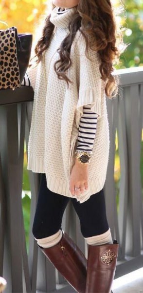 White chunky poncho sweater with turtleneck and sleeves over a long sleeve striped t-shirt