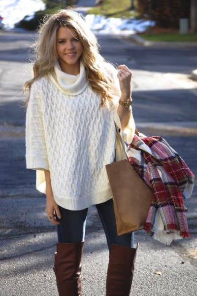 White turtleneck poncho with half sleeves and black skinny jeans
