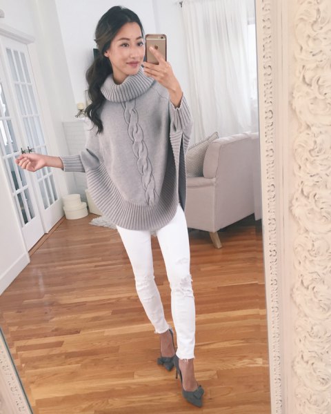 Gray cable-knit sweater with wide sleeves and white slim-fit
jeans