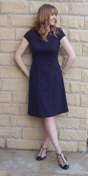 Navy blue short sleeve knee length flared dress with strappy flat shoes