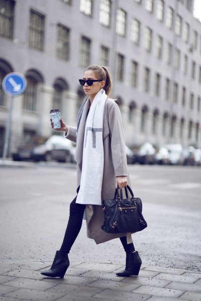 Light gray long wool coat with white long scarf and black leather wedge ankle boots
