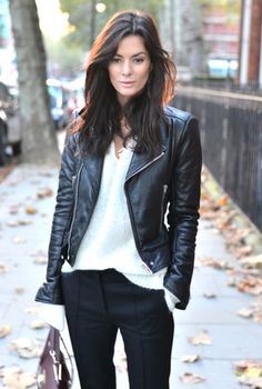 Biker jacket with a white V-neck knit sweater and black chinos