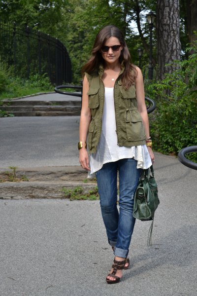 Green utility vest with white sleeveless tunic top and blue cuffed jeans