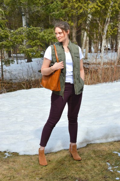 Green utility vest with white t-shirt and black slim-fit jeans