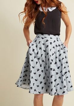 Black sleeveless top with white printed flared midi chiffon skirt with pockets