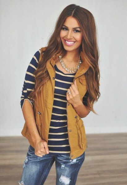 lime green hooded vest with navy and pink striped t-shirt and ripped jeans
