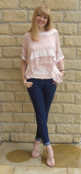 Half-sleeved lace blouse in rouge with a bateau neckline and dark blue skinny jeans with cuffs