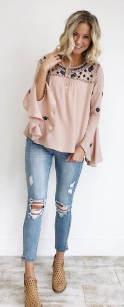 Rouge-black blouse with wide ruffled sleeves and ripped and cropped
jeans