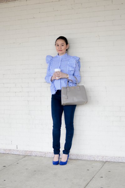 Blue and white striped blouse with ruffles on the shoulder and dark skinny jeans