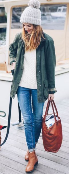 olive green jacket with white cable knit sweater and leather ankle boots