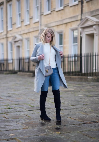 White sweater with gray long coat and blue tall jeans