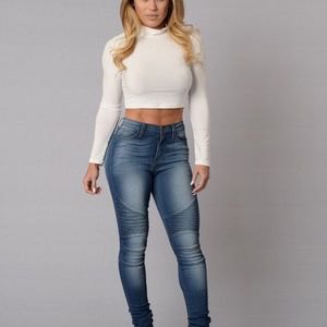 White cropped turtleneck bodycon sweater and blue high-waisted jeans
