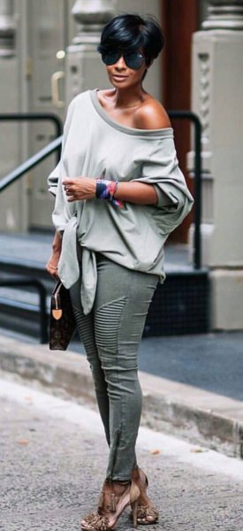 Gray one shoulder relaxed fit sweater paired with skinny jeans