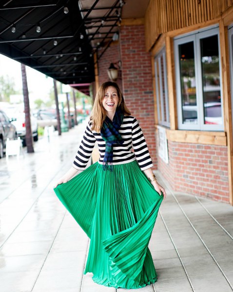 Black and white striped t-shirt with three-quarter sleeves and green pleated maxi skirt