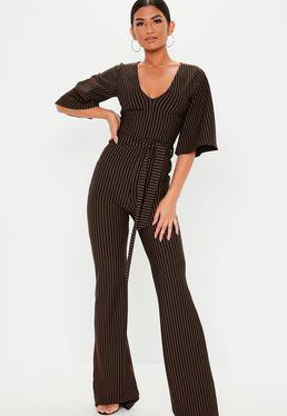 Black and white formal jumpsuit with vertical stripes, a V-neckline and wide, short sleeves
