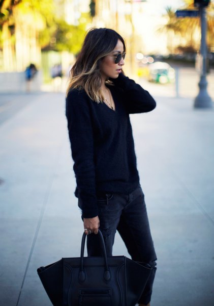 Black chunky knit V-neck sweater paired with dark slim-fit jeans