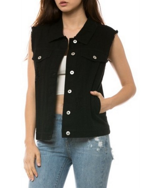 Black unwashed denim vest with white crop top and blue ripped
jeans