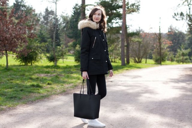 Black long coat with a faux fur hood and matching jeans and sneakers