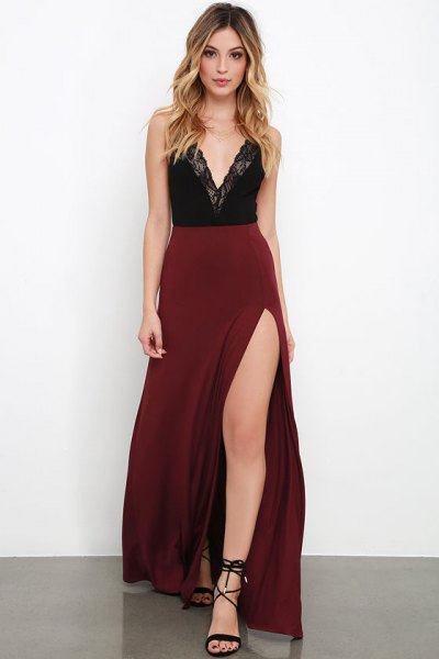 Black lace top with a deep V-neckline and high-waisted maroon maxi skirt with a slit