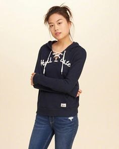 Black graphic hoodie with a lace-up neckline and dark blue skinny
jeans
