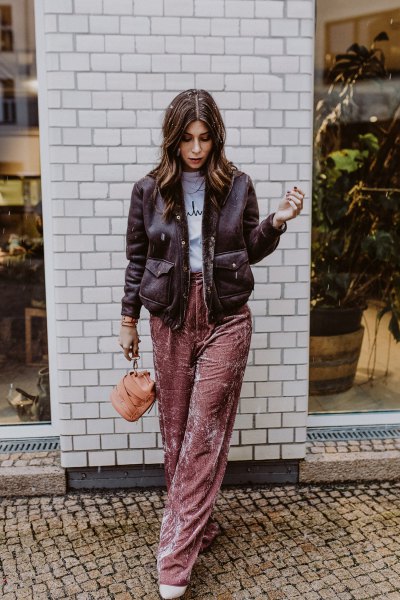 Black leather jacket with gray printed t-shirt and pink velvet wide-leg pants
