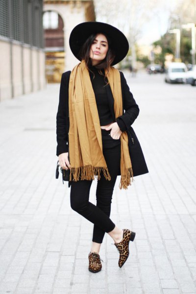 black longline blazer with orange fringed scarf and leopard print slippers