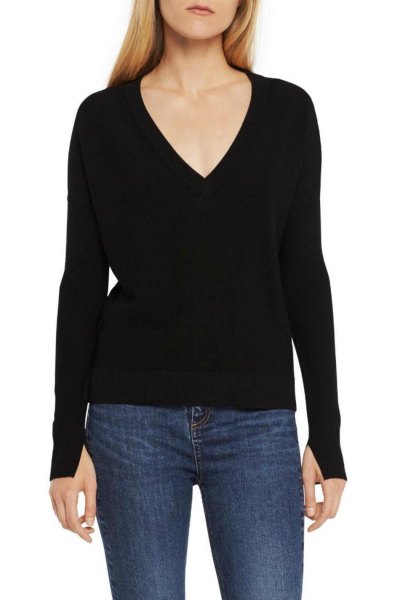 Black knit sweater with a deep V-neckline and dark blue skinny jeans
