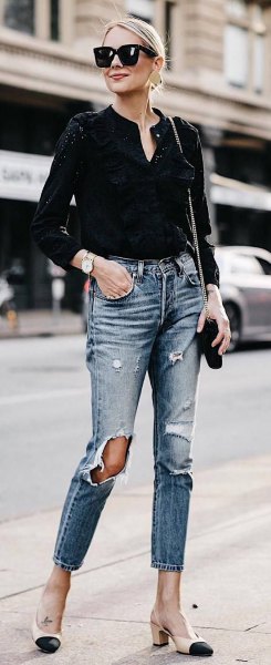 Black V-neck mini blouse and ripped, slim-fitting ankle jeans