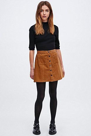 Black turtleneck with half sleeves and brown corduroy mini skirt with front button closure