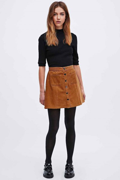 Black turtleneck with half sleeves and brown buttoned corduroy mini skirt