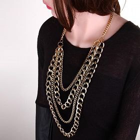 Black sweater with a scoop neckline and a statement gold chain