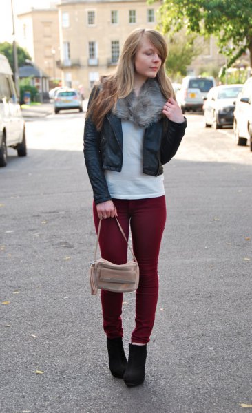 Black leather cropped bomber jacket with slim fit maroon jeans