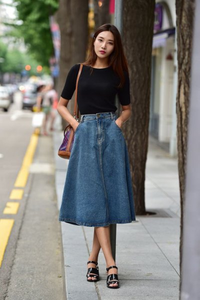 Black short sleeve fitted t-shirt with long blue denim skirt and sandals