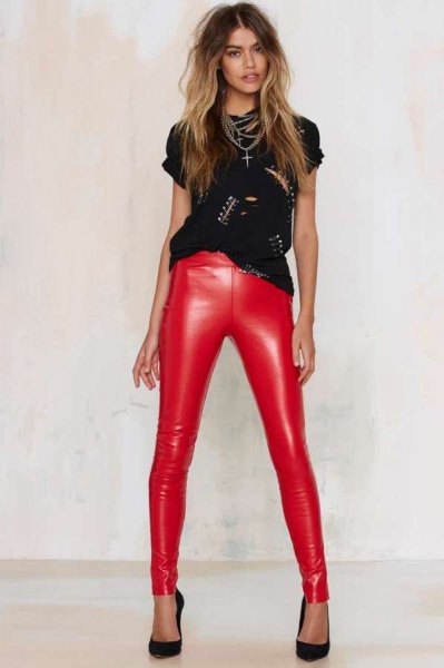 Black studded t-shirt with cutouts and red skinny leather pants