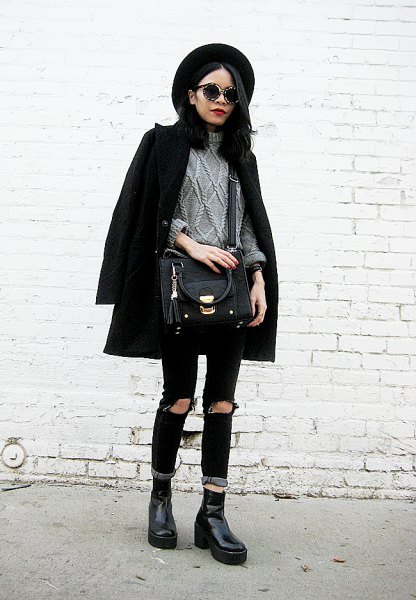Black wool coat with gray cable knit sweater and ripped jeans