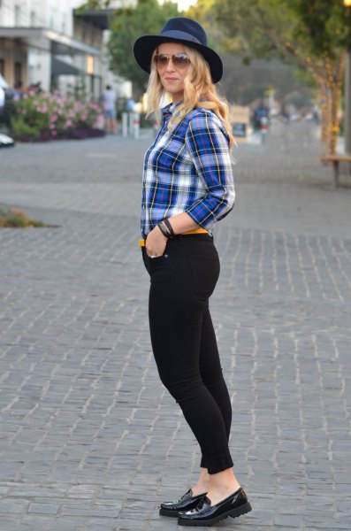 blue and white checked shirt with black, high-waisted drainpipe jeans and felt hat