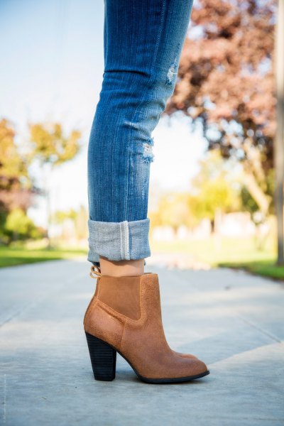 Blue cuffed jeans and brown leather boots with ankle boots