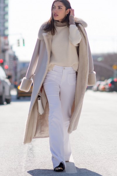 Pale pink long wool coat with faux fur collar and flared cream jeans