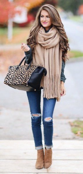 Pale pink fringed scarf worn with a gray jacket and skinny jeans with cuffs