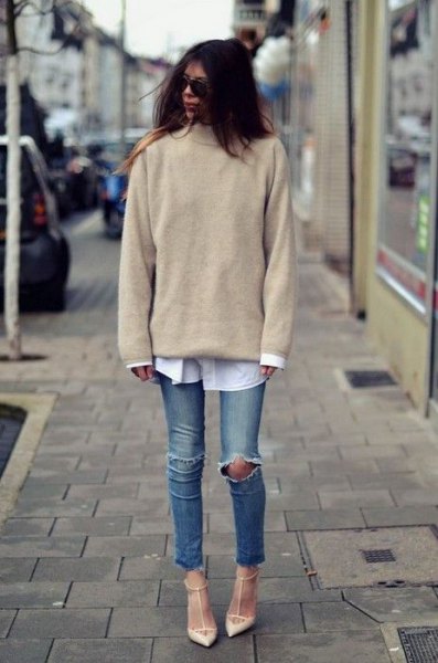 Light pink knit sweater with white button down shirt and ripped knee jeans