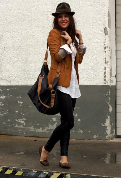 Brown blazer with white oversized button down shirt and black floppy hat