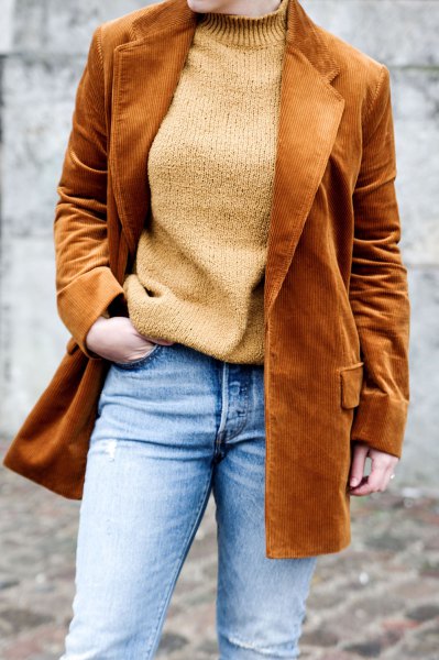 brown corduroy blazer with a green sweater and light blue jeans