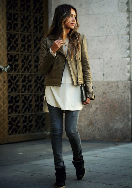 brown leather biker jacket with white tunic top and gray jeans