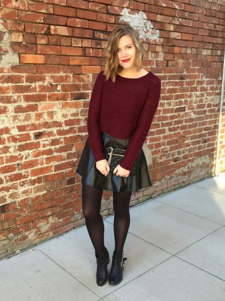 Burgundy fitted knit sweater with black leather mini skirt and
brown stockings