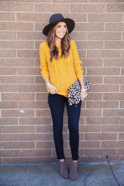 Mustard colored cable knit sweater with black felt hat and leopard print handbag