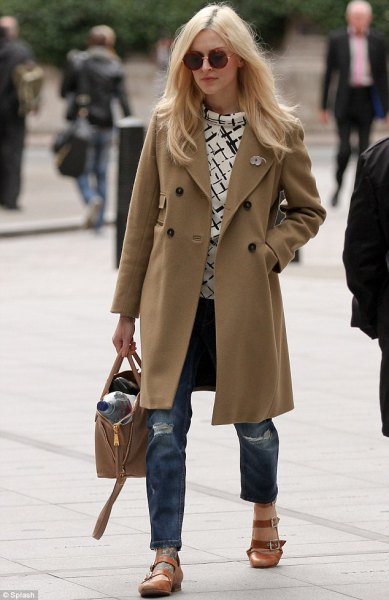 Camel colored long wool coat with ripped boyfriend jeans and tan round toe dress shoes