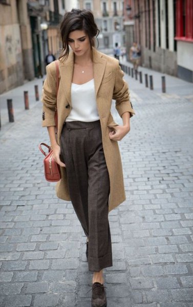 Camel colored long wool coat with a white silk top and gray wide-leg trousers